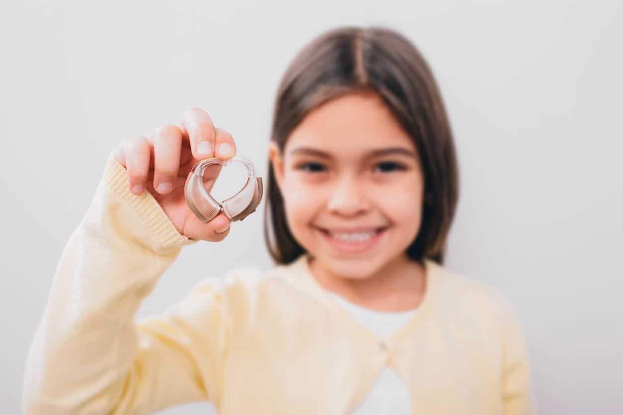 Girl Holding Hearing Aids