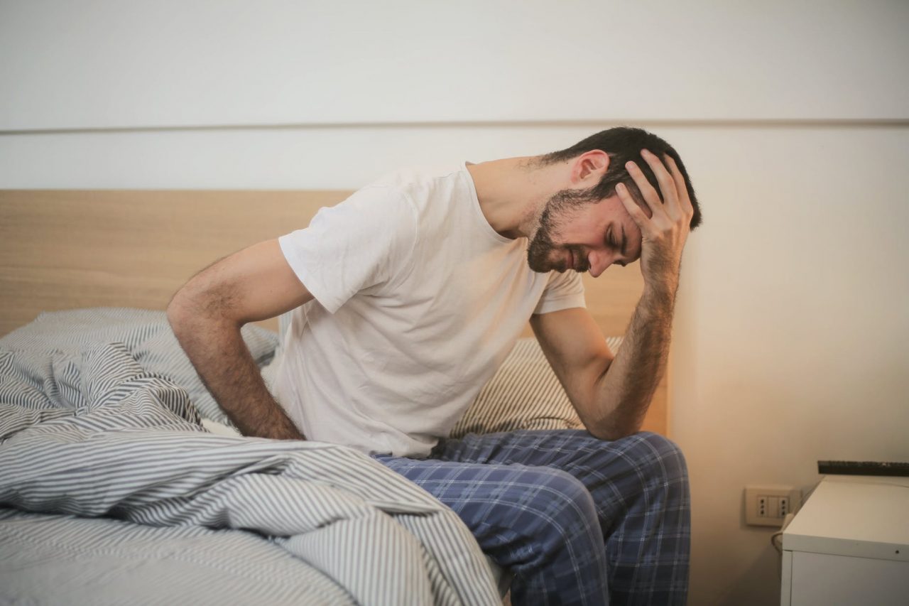 Man sitting on edge of bed