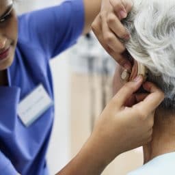 Woman being fitted with a hearing aid.