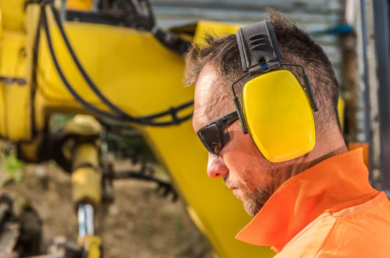 Man wearing protective headphones while working construction.