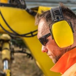 Man wearing protective headphones while working construction.