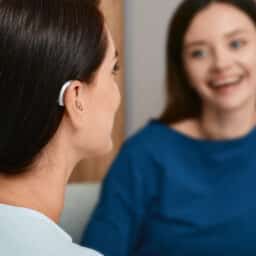 Woman with hearing aid chats with friend